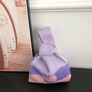 Stylish purple and pink knitted handbag featuring a unique knot handle design for women.