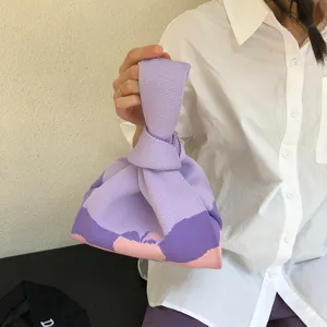 Close-up view of a purple knit knot bag featuring a stylish abstract color block design.