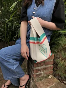 Handmade knit tote bag with colorful stripes and heart pattern detail for daily wear.