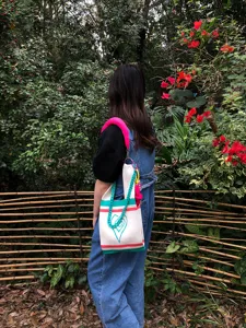 Outdoor lifestyle detail shot showcasing a handmade knitted tote bag with colorful chain strap.