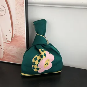 Sac à poignet noué en tricot vert avec un joli motif de fleur rose et de beaux carreaux.