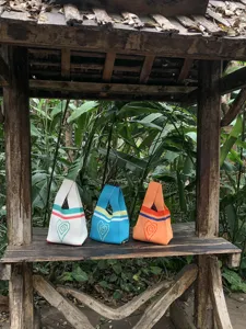 Outdoor detailed view of knitted tote bags featuring cute heart patterns and vibrant stripes.