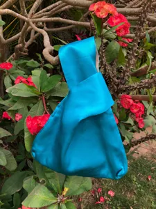 Nahaufnahme Detail einer leuchtend blauen japanischen Knoten Satin Handtasche im Freien.