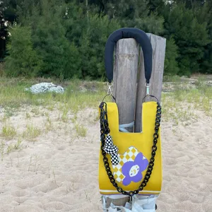 Joli sac cabas en tricot jaune avec motif de fleurs violettes et chaîne noire stylée.