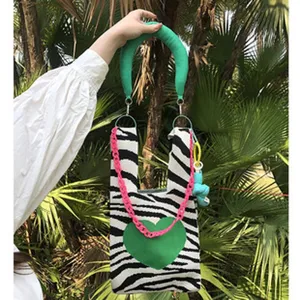 Detailansicht der niedlichen handgemachten Strick-Tasche mit trendigem Zebramuster und grünem Herz.