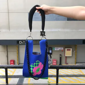 Sac cabas en tricot bleu avec motif de fleur rose et bandouliere chaine noire pour femmes.