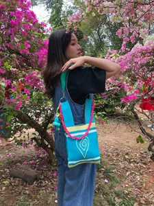 Handmade knit tote bag with vibrant pink chain strap and cute heart pattern, stylish detail view.