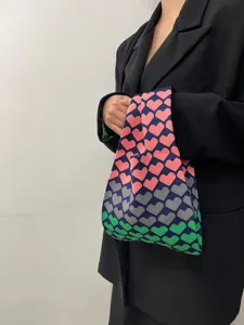 Detail shot of colorful gradient heart knit tote bag showcasing texture and wrist design.