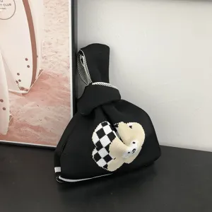 Vue rapprochée du sac noué en tricot noir avec un joli motif d'ours à carreaux et texture.