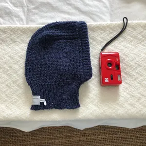 Navy blue knitted balaclava detail view, showing soft woolen texture, ear protection design.