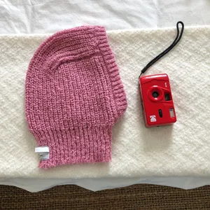 Pink knitted balaclava hat detail, cozy winter thermal headwear with cute label design.