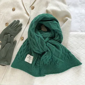 Donkergroene grof gebreide winterscarf detail, dikke en warme accessoire platliggende opstelling.