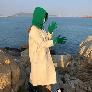 Comfortabele gebreide balaclava muts en bijpassende groene handschoenen voor de winter.