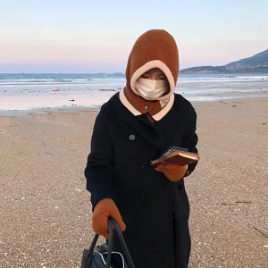 Detail view of the winter knitted hooded scarf and gloves set in brown, cozy and warm.