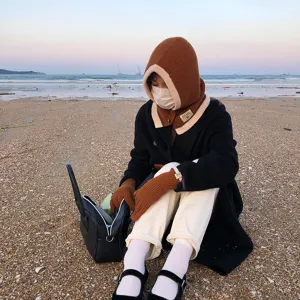 Winter knitted hooded scarf set and touchscreen gloves detail, fashionable outdoor wear.