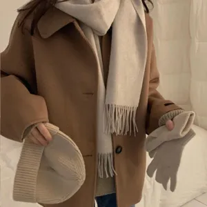 Primer plano detallado de bufanda de lana con flecos, textura muy suave y elegante estilo invernal.