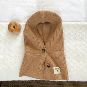 Gebreide bivakmuts detail, warme wollen capuchon met knopen, gezellig winteraccessoire.