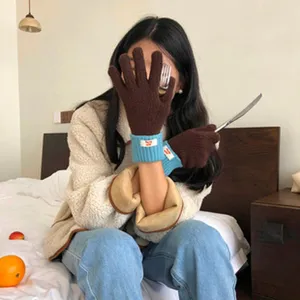 Detailansicht von warmen Plüschhandschuhen mit farbig kontrastierenden Bündchen im Winter.