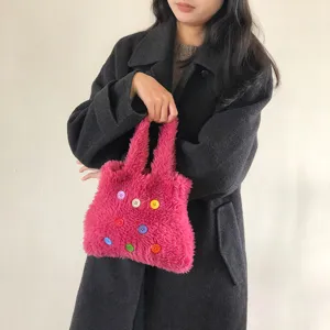 Pink fluffy handbag detail, cute plush purse with colorful buttons, casual winter accessory.