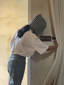 Detail view of a stylish black and white houndstooth knitted balaclava hood scarf for cozy winter wear.