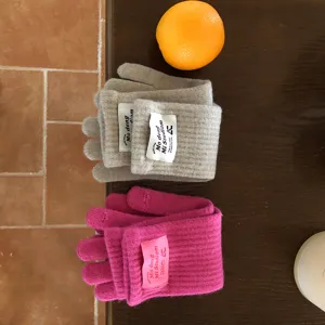 Detailansicht winterlicher Strick-Wollmischung Touchscreen-Handschuhe in Grau und Pink.