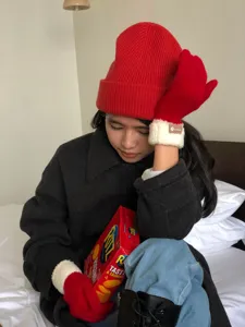Red knit beanie hat and warm winter fleece cuff gloves detail shot cozy lifestyle