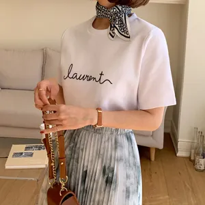 Silk scarf detail matching with white t-shirt and pleated skirt for stylish daily wear.