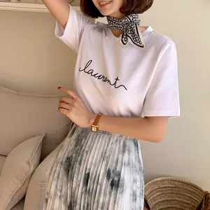 Stylish women's white short-sleeve t-shirt paired with a chic printed silk scarf for elegant outfits.