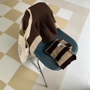 Gemütlicher, warmer Strickschal mit klassischen braun-beigen Streifen für kalte Wintertage.