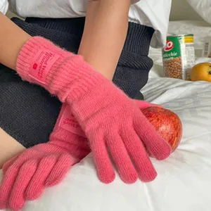 Detailaufnahme von rosa Strick-Touchscreen-Winterhandschuhen für Damen, weiches Wollmaterial.