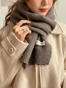 Brauner Strickschal Detailansicht im Winter, weiche Textur, warme Halstuch Nahaufnahme.
