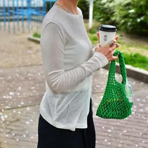 Nahaufnahme der grünen gestrickten Netztasche, die die strukturierte hohle Handwerkskunst zeigt.