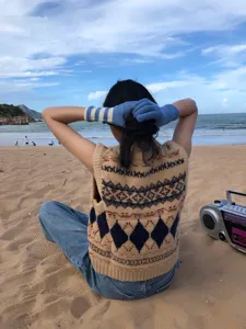 Nahaufnahme von kuscheligen Strickhandschuhen am Strand für herbstlichen und winterlichen Look.