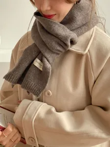 Nahaufnahme eines weichen Strick-Winterschals in Dunkelbraun, elegant zu Mantel.