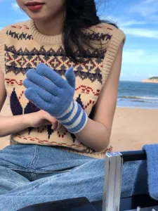 Nahaufnahme Detail von blau-weißen gestreiften Touchscreen-Strickhandschuhen für den Herbst.