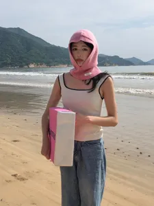Vue détaillée de la cagoule tricotée rose à la plage, en laine douce, chaude pour l'hiver.