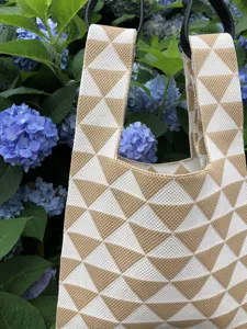 Vista dettagliata della borsa tote in maglia con motivo a triangolo geometrico e design spazioso.