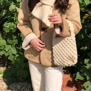 Gedetailleerd overzicht van een stijlvolle mini gebreide handtas in beige met bubbeltextuur.