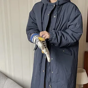 Nahaufnahme von gemütlichen gestreiften Winterstrickhandschuhen zum blauen Mantel.