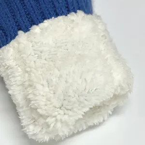 Detailaufnahme der winterlichen Strickhandschuh Manschette mit weichem Plüsch Material.