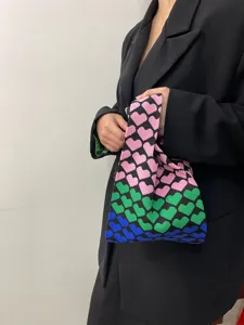 Close-up detail of the stylish knitted tote bag featuring a vibrant gradient heart pattern.