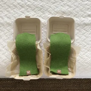 Dettaglio guanti lavorati a maglia verde senza dita, accessorio termico invernale accogliente.