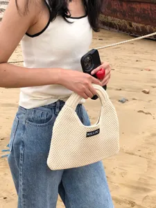Nahaufnahme Detailansicht der beigen geflochtenen Strick Handtasche im Strand Außenbereich.