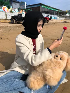 Vue détaillée d'une cagoule en tricot noir sur une plage, montrant texture et style de vie.