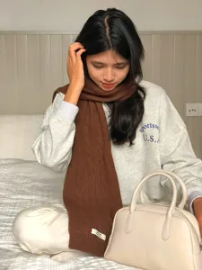 Gemütlicher brauner Strickschal Detailaufnahme, weiche Wolle Textur für Winterwärme Mode.