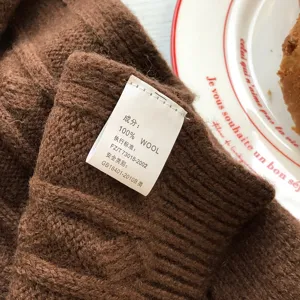 Braune reine Wolle Strickschal Detailansicht mit weicher Textur und Produktetikett.