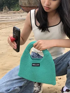 Detailansicht einer stilvollen türkisfarbenen Strick-Umhängetasche für Damen Strand.