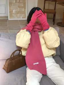 Gemütliches rosa Strickschal- und Handschuh-Set im Detail, warme Winteraccessoire-Ansicht.