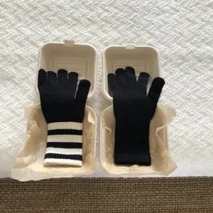 Detailansicht der Strick-Touchscreen-Handschuhe, gestreifte und schwarze Winterstile.