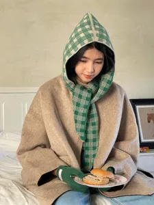 Knitted hooded scarf detail showcasing green grid pattern, warm winter accessory close up